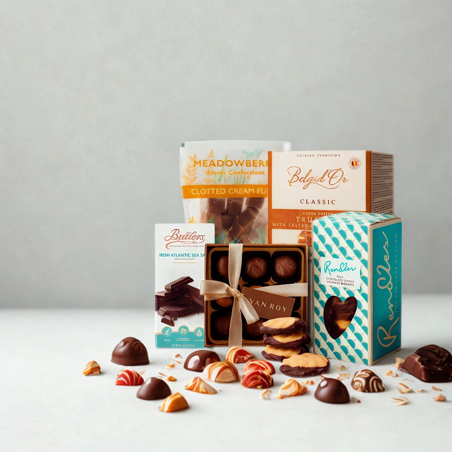 Assorted chocolate truffles and boxes on a white surface with a gray background