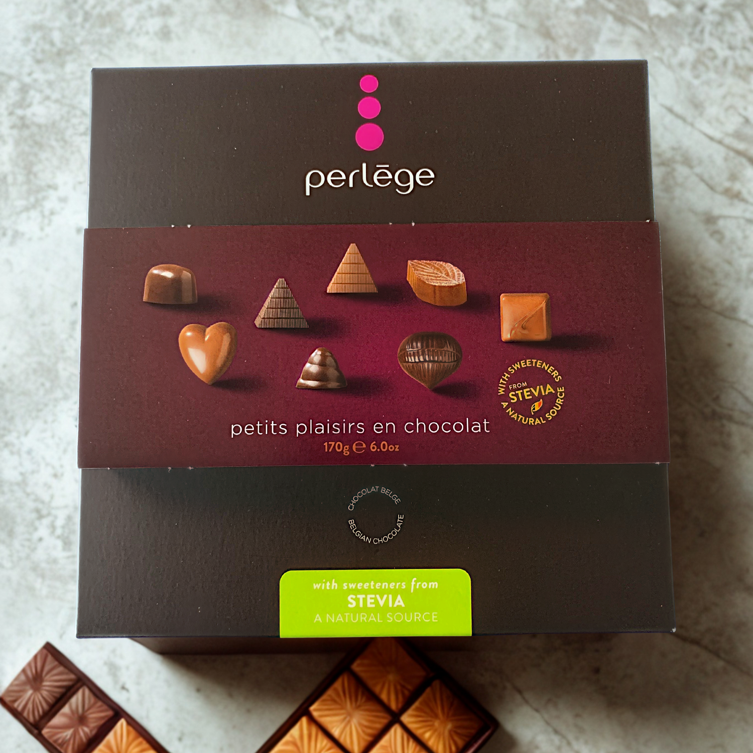 Perlege chocolate box with various chocolate pieces on a textured surface