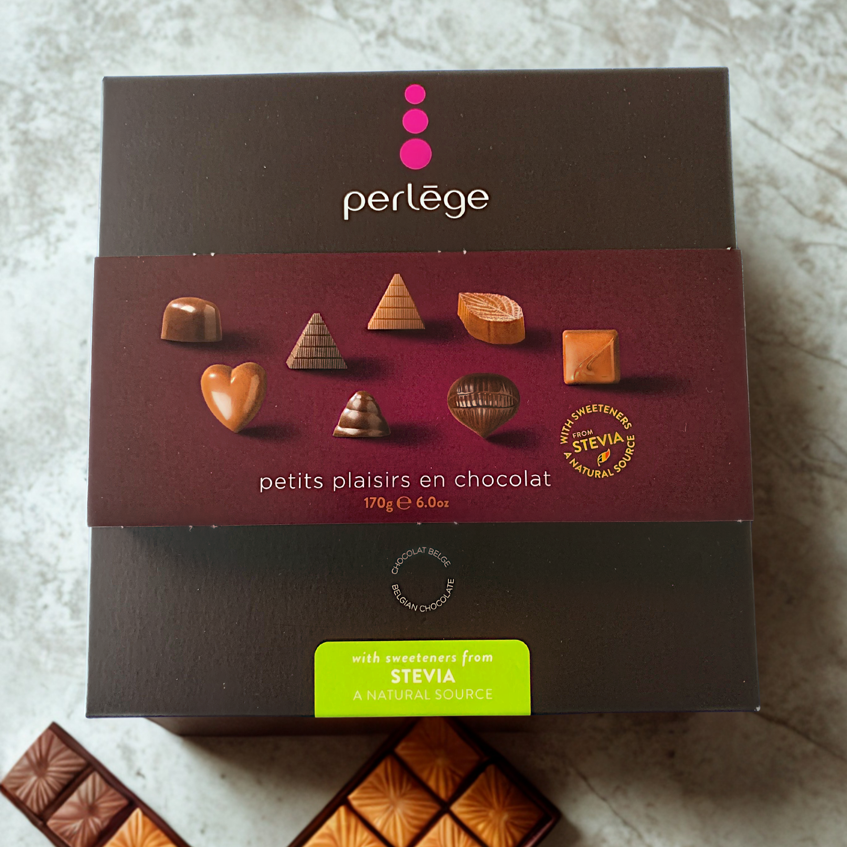 Perlege chocolate box with various chocolate pieces on a textured surface