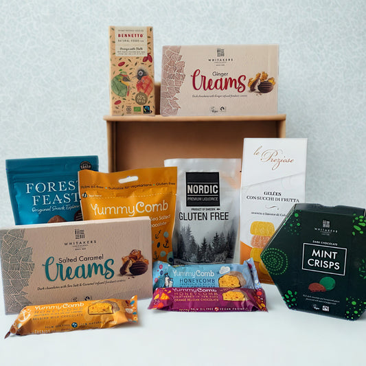 Assorted gluten free food products including boxes, bags, and packets on a white surface with a light gray background.