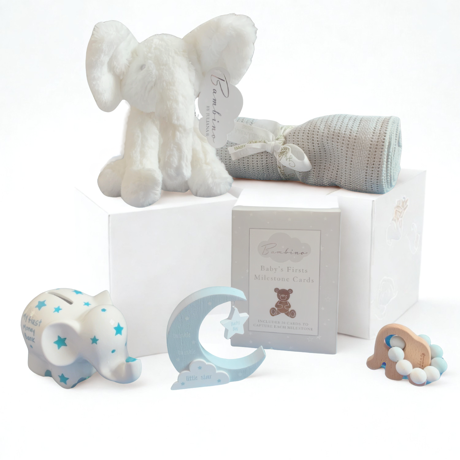Collection of baby items including a plush elephant, baby blanket, and decorative elements on a white background.