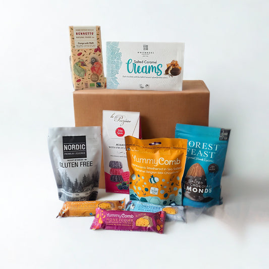 Collection of various gluten free food products including snacks and baked goods on a white background