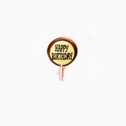 Chocolate lollipop with 'Happy Birthday' text on a white background
